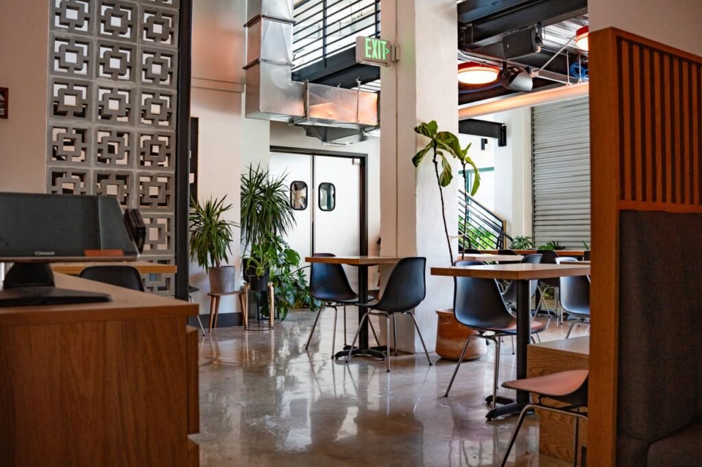 Home Contemporary cafe interior showcasing industrial style with plants and minimalist furniture.