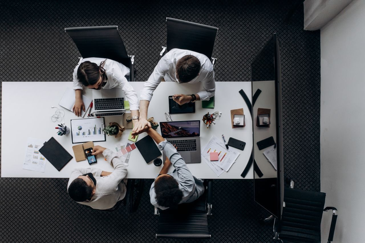 About High angle view of colleagues collaborating around a conference table in a modern office setting.